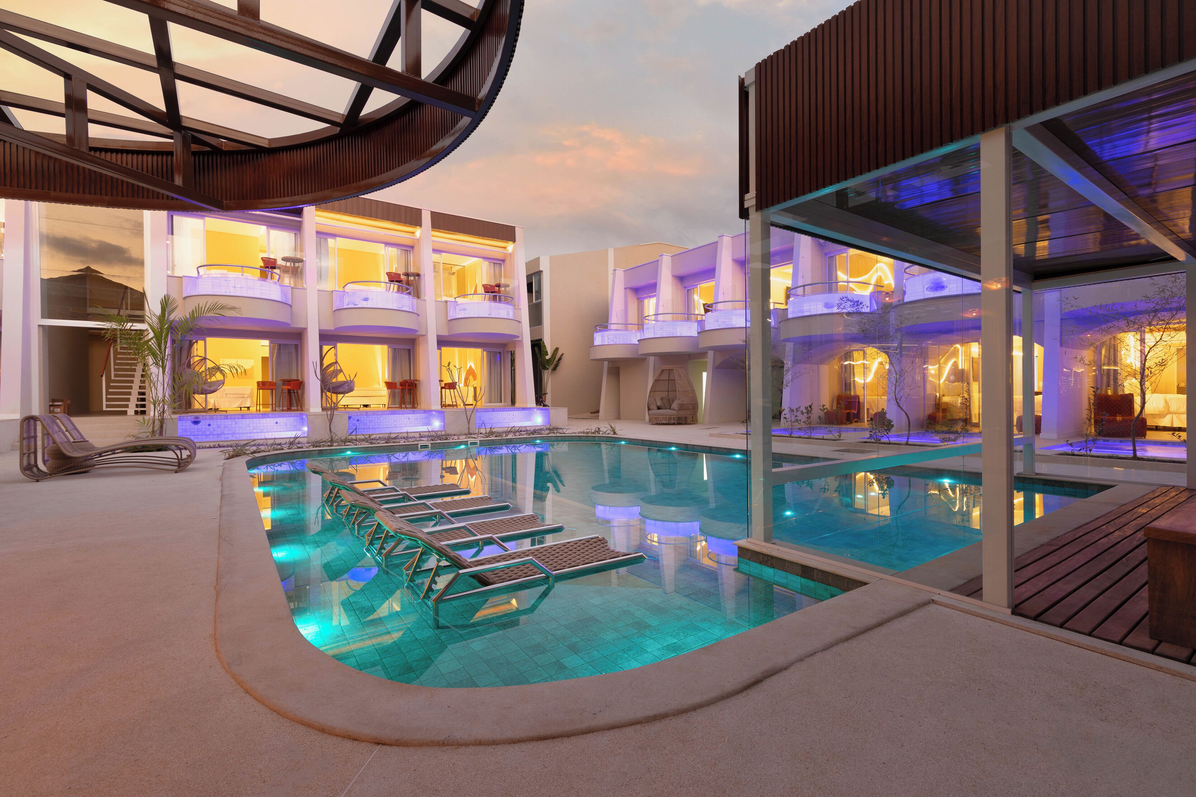 Una piscina al aire libre, sillones reclinables de piscina