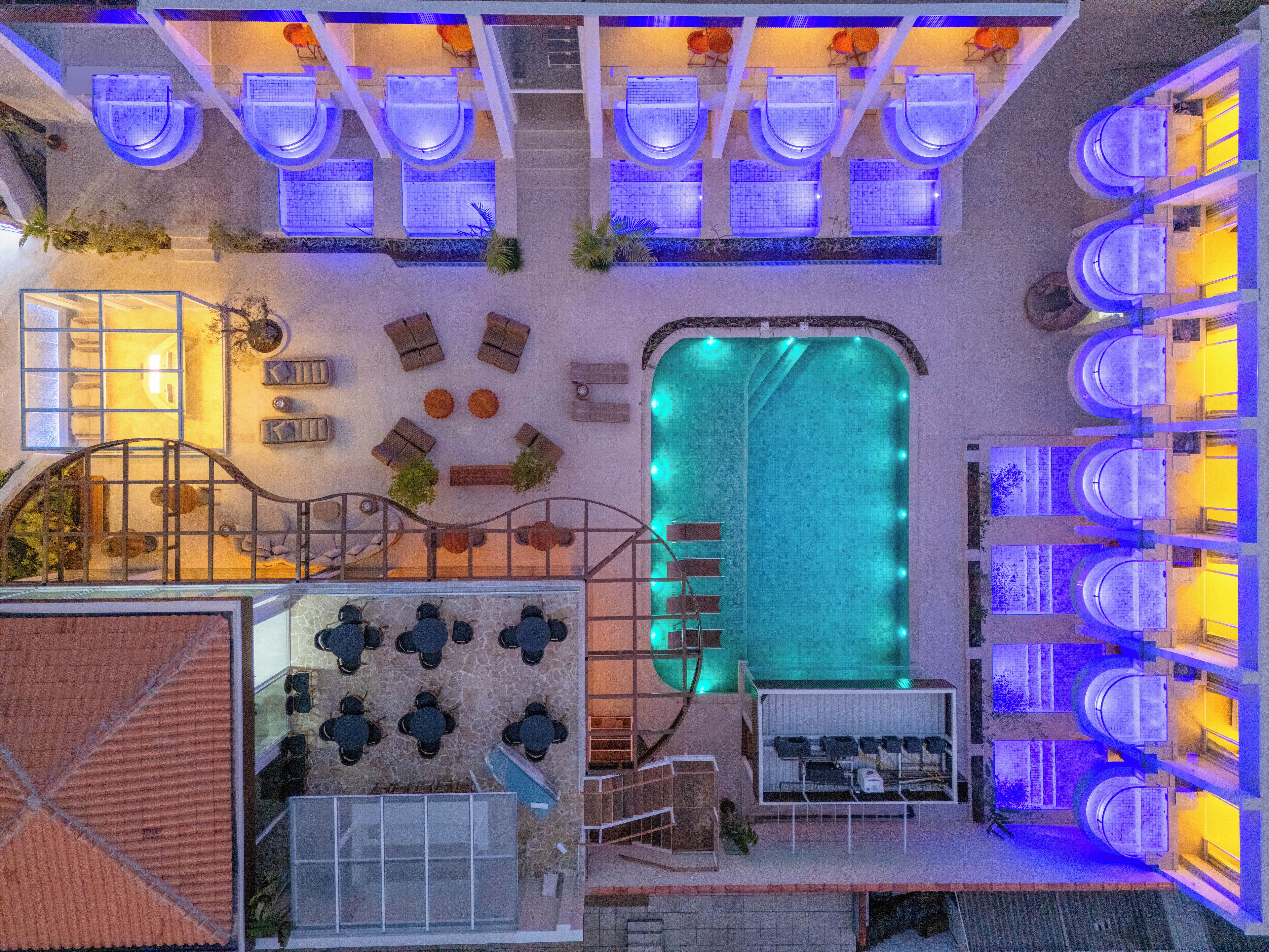 A rooftop pool area with multiple seating arrangements and a central swimming pool.