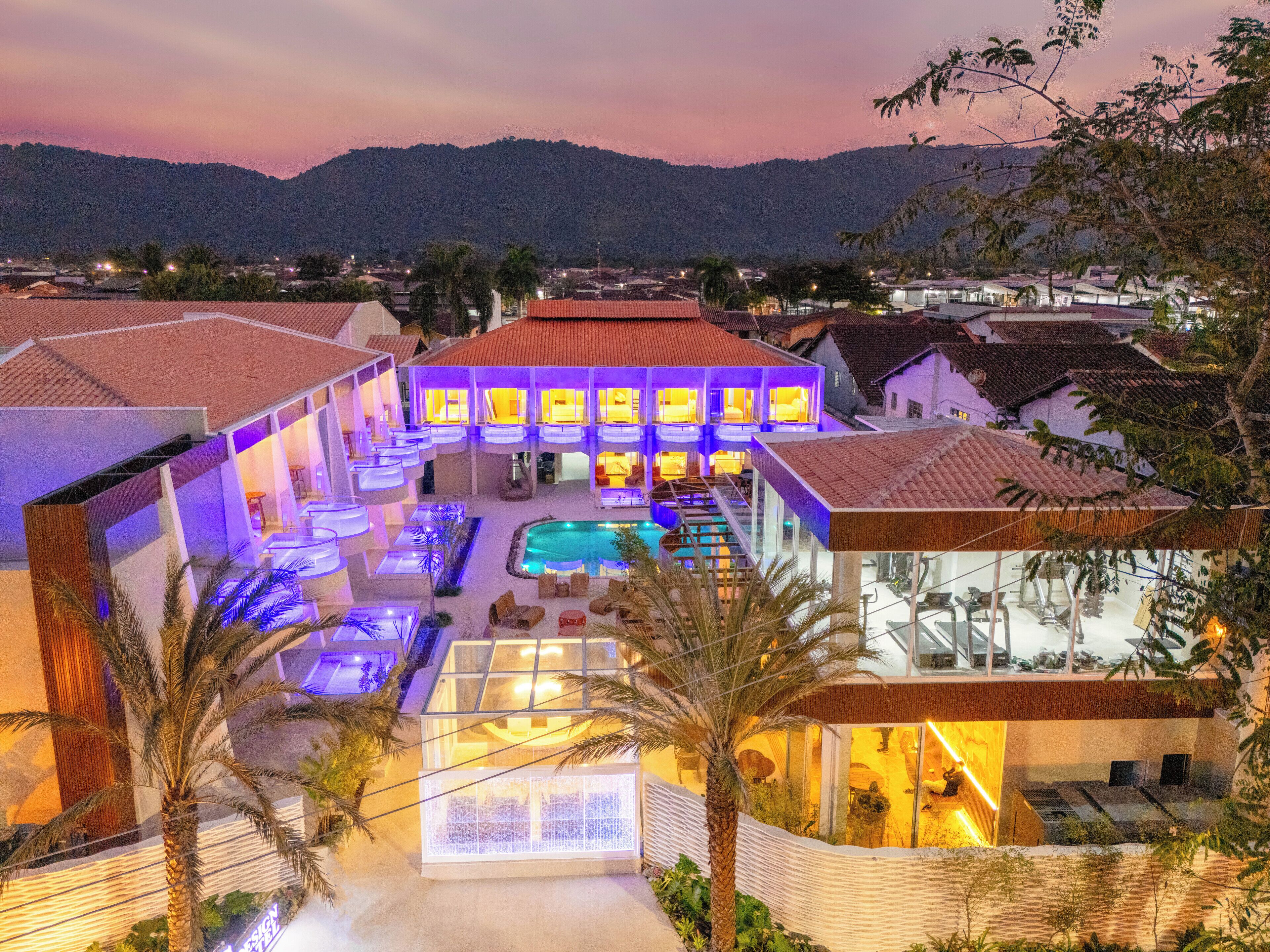 Un hotel con varias habitaciones, piscina y vistas del paisaje circundante.