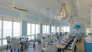 A spacious dining area with high ceilings, large windows, and a view of the ocean. - Spacious 3-bedroom condo minutes from beach with access to resort-like amenities (Naples)