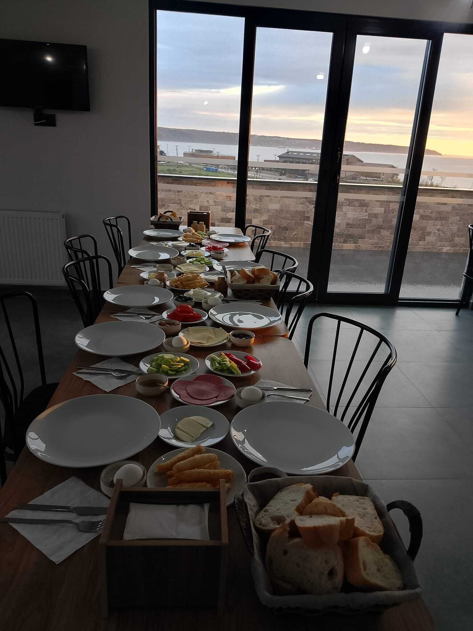 Une table à manger dressée avec des assiettes, des bols et du pain, offrant une vue panoramique.