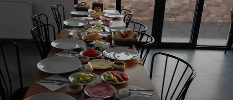 Une table à manger dressée avec des assiettes, des bols et du pain, offrant une vue panoramique.