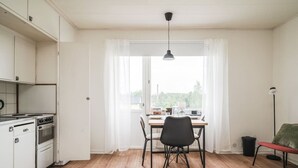 A kitchen with a stove, cabinets, and a dining area with a table and chairs.