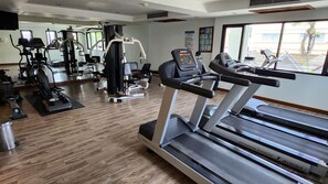A gym with treadmills, elliptical machines, and weight equipment. - Fantastic apartment with AC and great pool in Kalim Patong by the Sea (Tambon Patong)