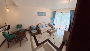 A living room with a sofa, chairs, a coffee table, and a dining table.