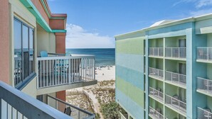 A hotel with balconies overlooking a beach.