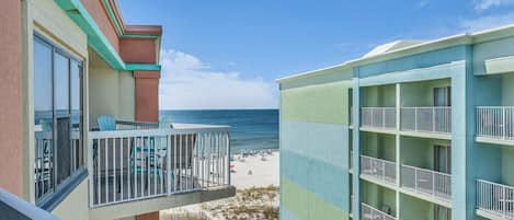 A hotel with balconies overlooking a beach.
