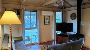 Una sala de estar acogedora con un sofá, un televisor, una chimenea y una ventana con cortinas.