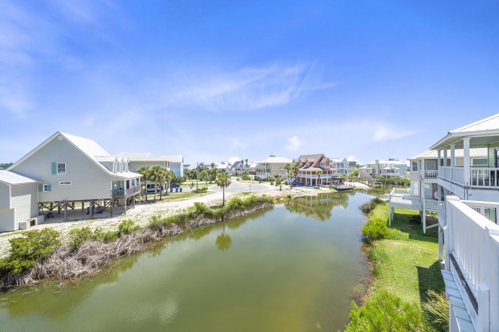 A coastal property with multiple buildings, a river, and a sandy beach.