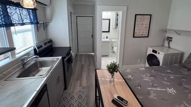 Una cocina compacta con lavamanos, cocina y comedor con mesa y sillas.