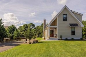 A single-story house with a front porch, a chimney, and a well-maintained lawn.