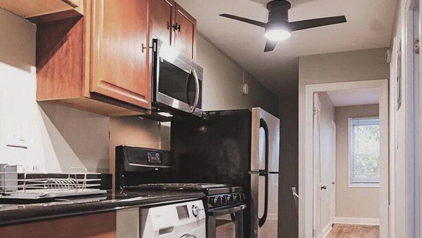 A kitchen with a stove, microwave, refrigerator, and washing machine. - Private 1 Bedroom/1Bathroom Apartment in Heart of DC! (Washington)