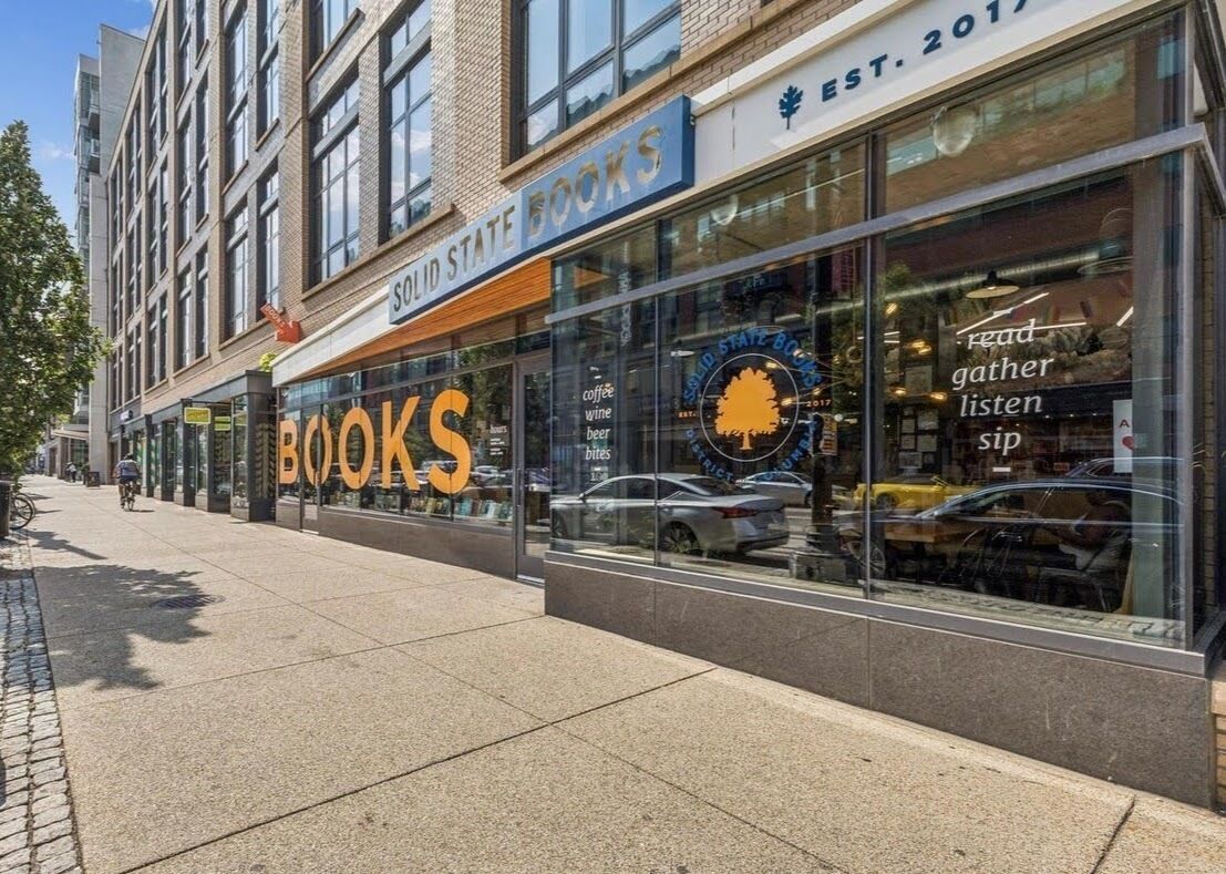 Une devanture de magasin avec une grande enseigne indiquant « LIVRES » et une autre, plus petite, au-dessus, indiquant « LIVRES À ÉTATS SOLIDES ».