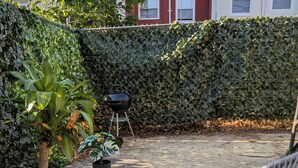 A patio with wicker chairs, a round table, and a potted plant. - Private 1 Bedroom/1Bathroom Apartment in Heart of DC! (Washington)