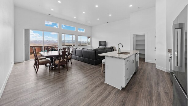 A spacious kitchen with a dining area, a built-in island, and a large window overlooking a mountainous landscape. - Welcoming 3-bedroom suite in Gardnerville, NV near Topaz Lake. (Gardnerville)