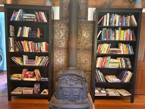 A room with two black bookshelves filled with books, a decorative central column, and a patterned wall. - New! A Waterfront Retreat on 14 Acres with 7 Bedrooms That Sleeps 13! (Stella)