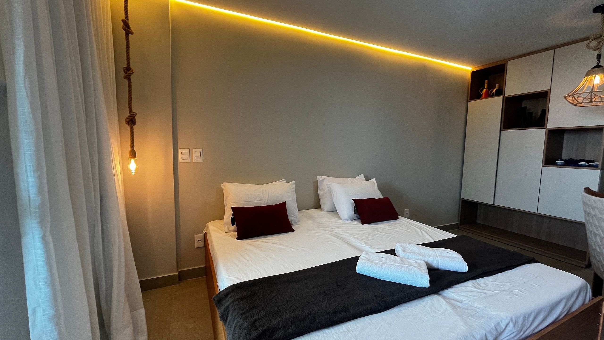 Une chambre d’hôtel avec un lit, un bureau et une armoire.