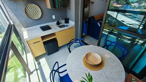 A modern kitchen with a dishwasher, a sink, and a round table with a hat on it. - Beach Class Summer Residence (Ipojuca)
