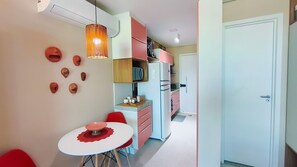 A compact kitchen with a refrigerator, microwave, and a small dining table with chairs. - Beach Class Summer Residence (Ipojuca)
