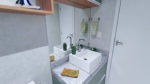 Une salle de bain avec deux lavabos, un miroir et une étagère au-dessus du lavabo.