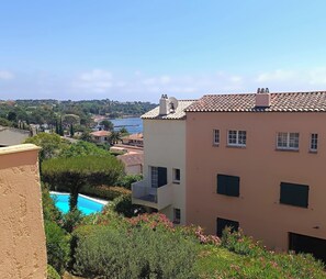 A building with a swimming pool, a view of the sea, and a garden with pink flowers. - Studio 🔆 just a few meters from the beach.  Ideal for couples or solo. (Agay)