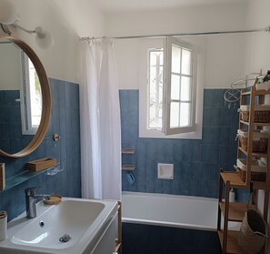 A bathroom with a bathtub, a shower, a sink, a mirror, and a window. - Studio 🔆 just a few meters from the beach.  Ideal for couples or solo. (Agay)