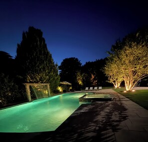 A swimming pool with a waterfall feature, surrounded by trees and a paved walkway. - Southampton Paradise with Saltwater Pool & Spa & 3 minutes to Best Beach in USA (Southampton)