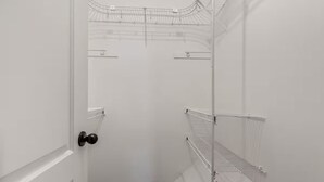 Un dressing accessible sans porte, doté d’étagères ouvertes.