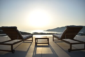 A sunlit terrace with two lounge chairs and a small table, overlooking a scenic coastal view. - Prime Views B - Peacefull Villa with Private Pool, premium Sea view and Sunsets. (Poseidonia)
