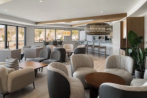 A modern hotel lobby with seating areas, a bar, and large windows. - Hotel Indigo North Conway by IHG (North Conway)