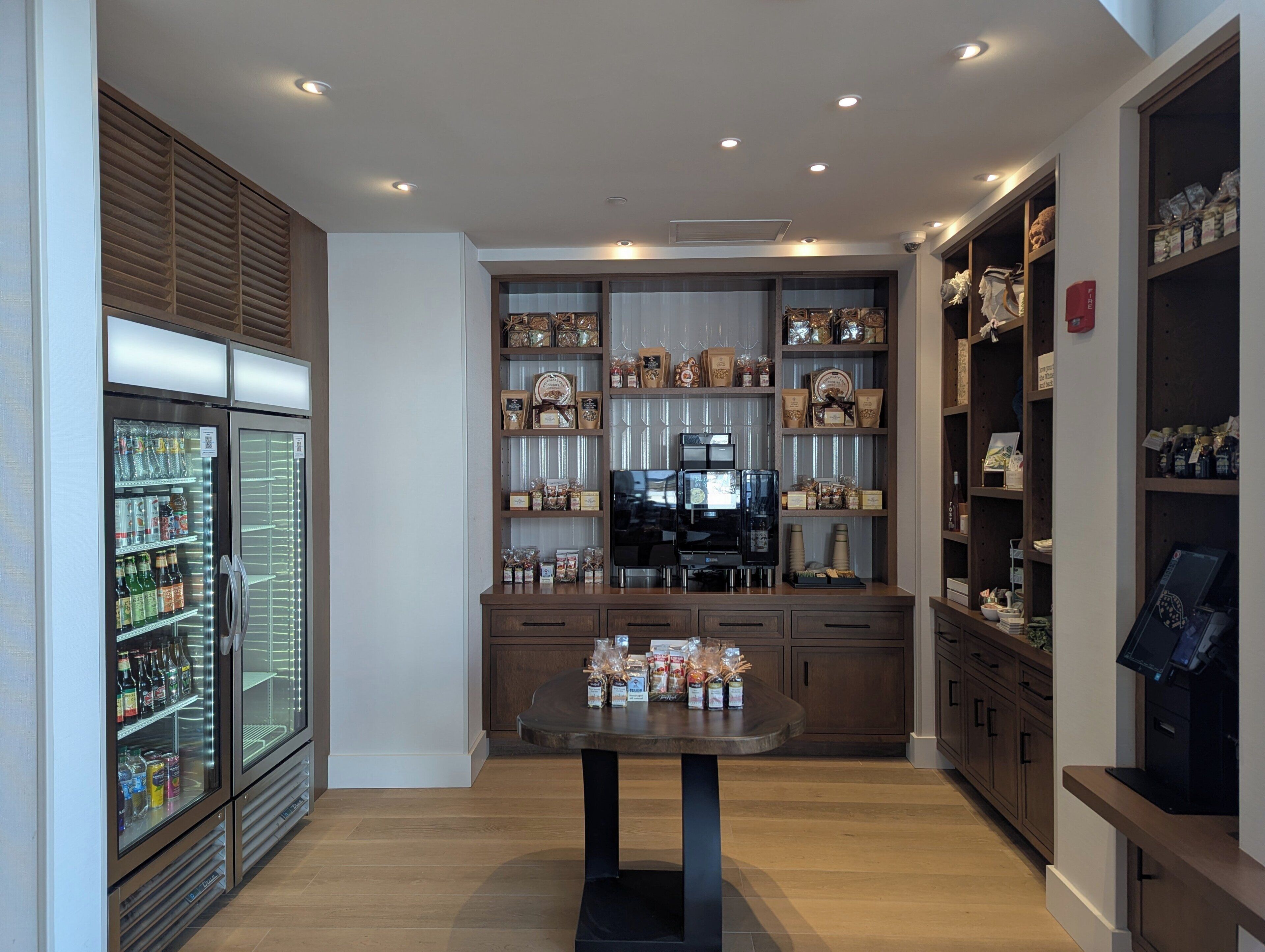 A modern kitchen with a central island, built-in shelves, and a refrigerator.