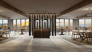 Un comedor amplio con techos altos, ventanas grandes que ofrecen vistas a la ciudad y muebles modernos.