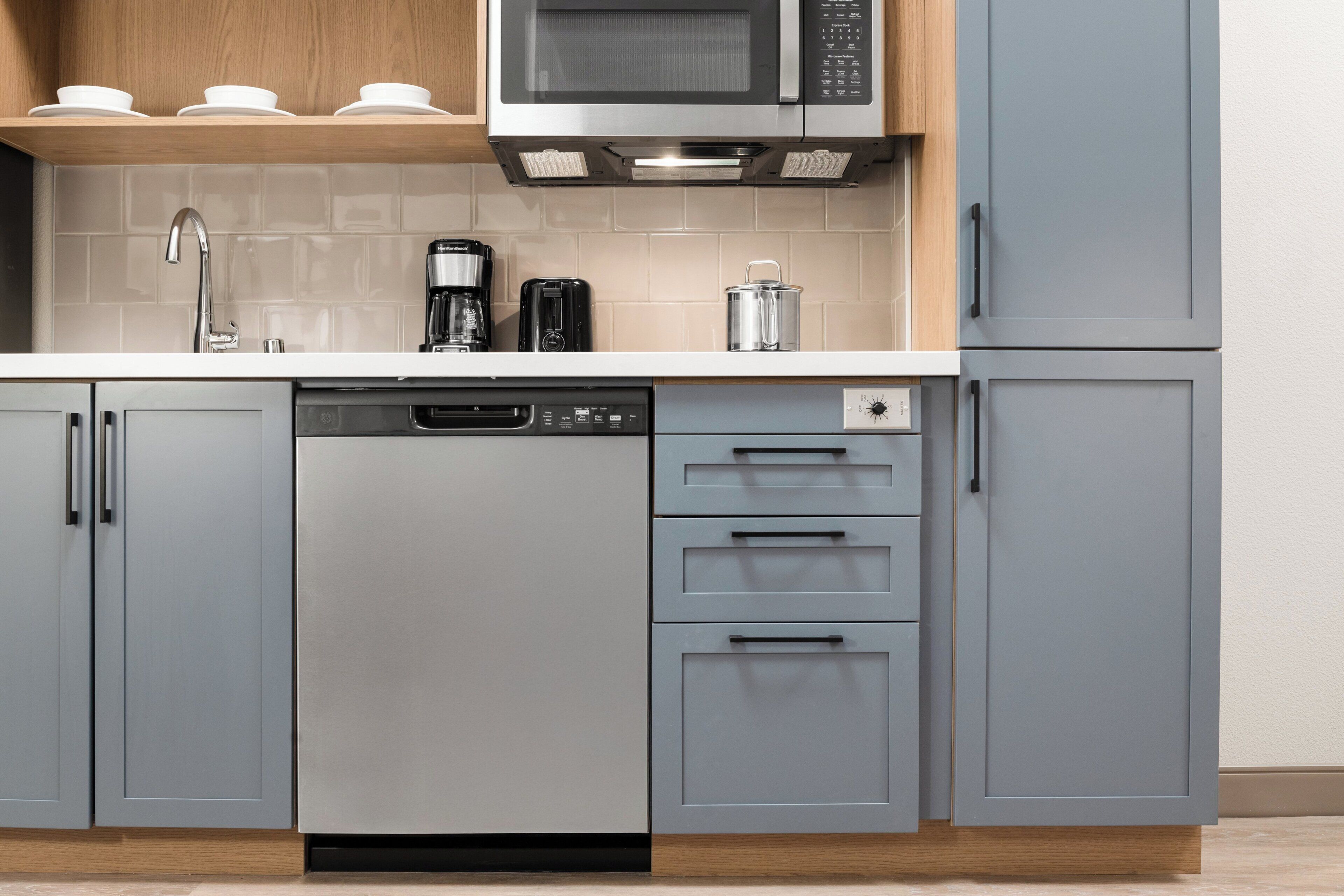 A kitchen with a dishwasher, a coffee maker, and a microwave.