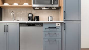 Uma cozinha equipada com lava-louças, cafeteira e micro-ondas.