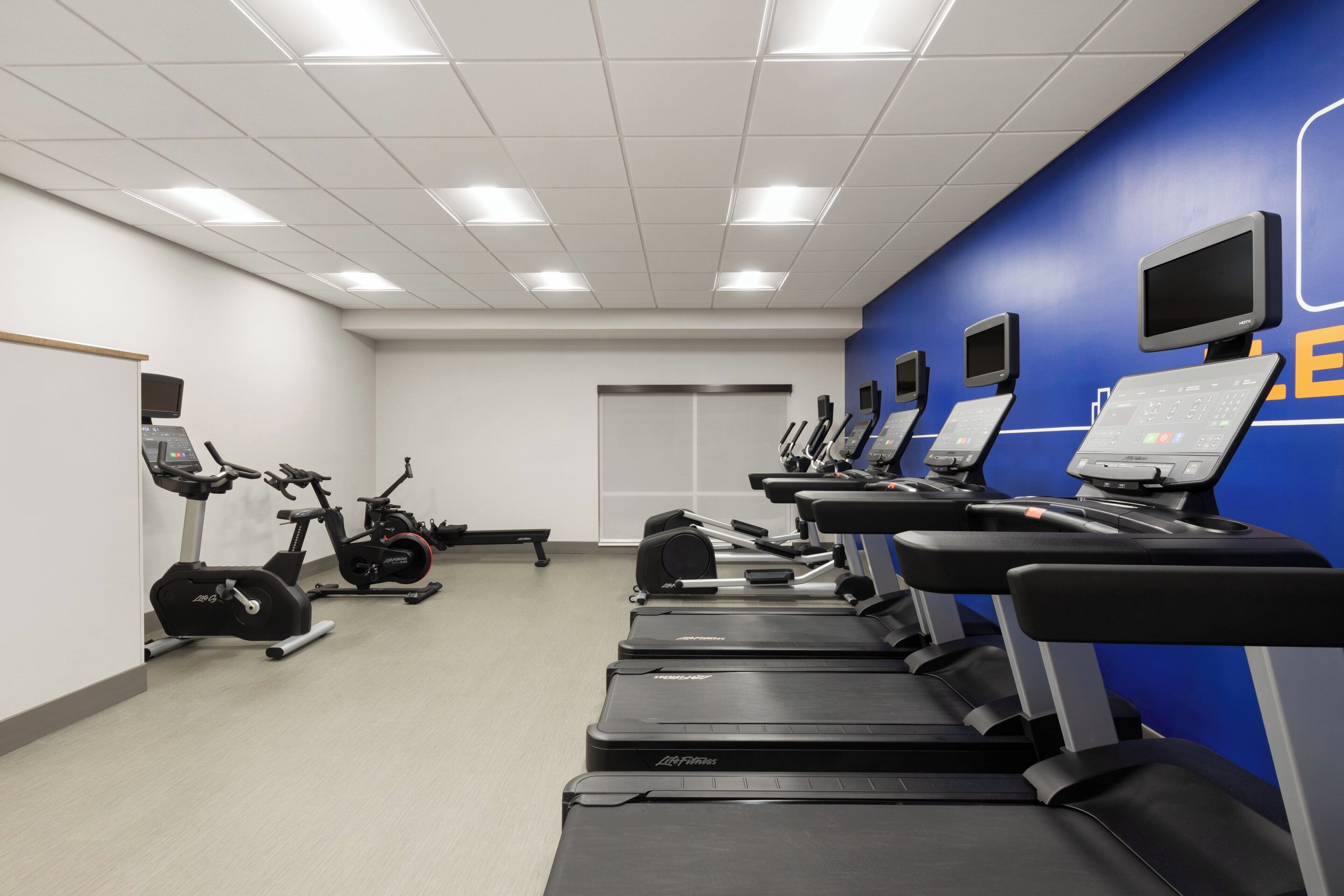 A fitness center with treadmills, stationary bikes, and weight machines.