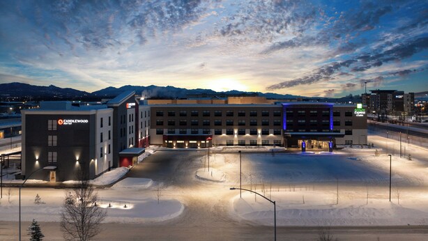 Een hotel met een parkeerplaats, een gebouw met een 'Candlewood' bord en een 'Hampton Inn Express' bord.