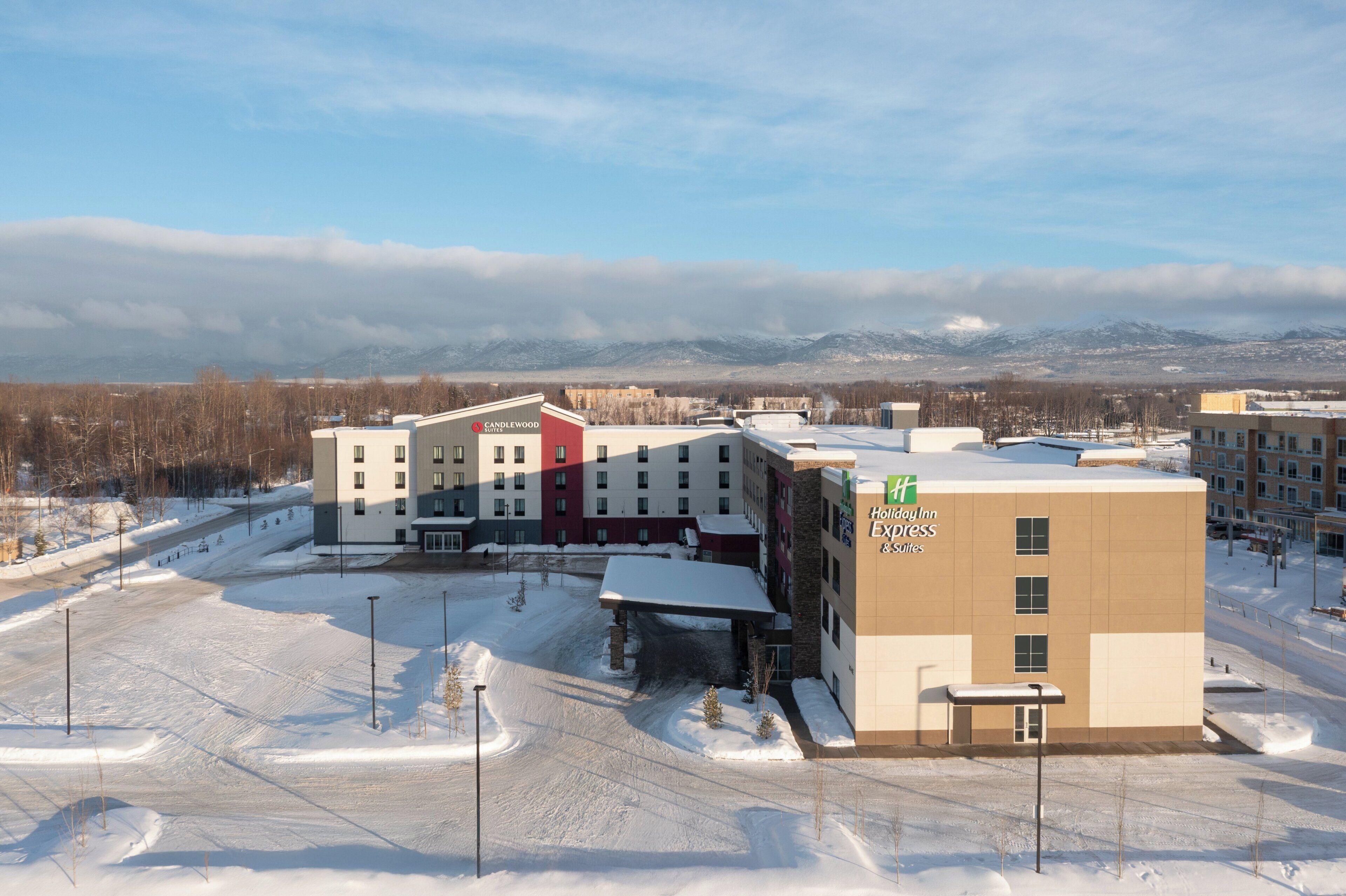 Un hotel con varias edificaciones, un estacionamiento y terreno cubierto de nieve.