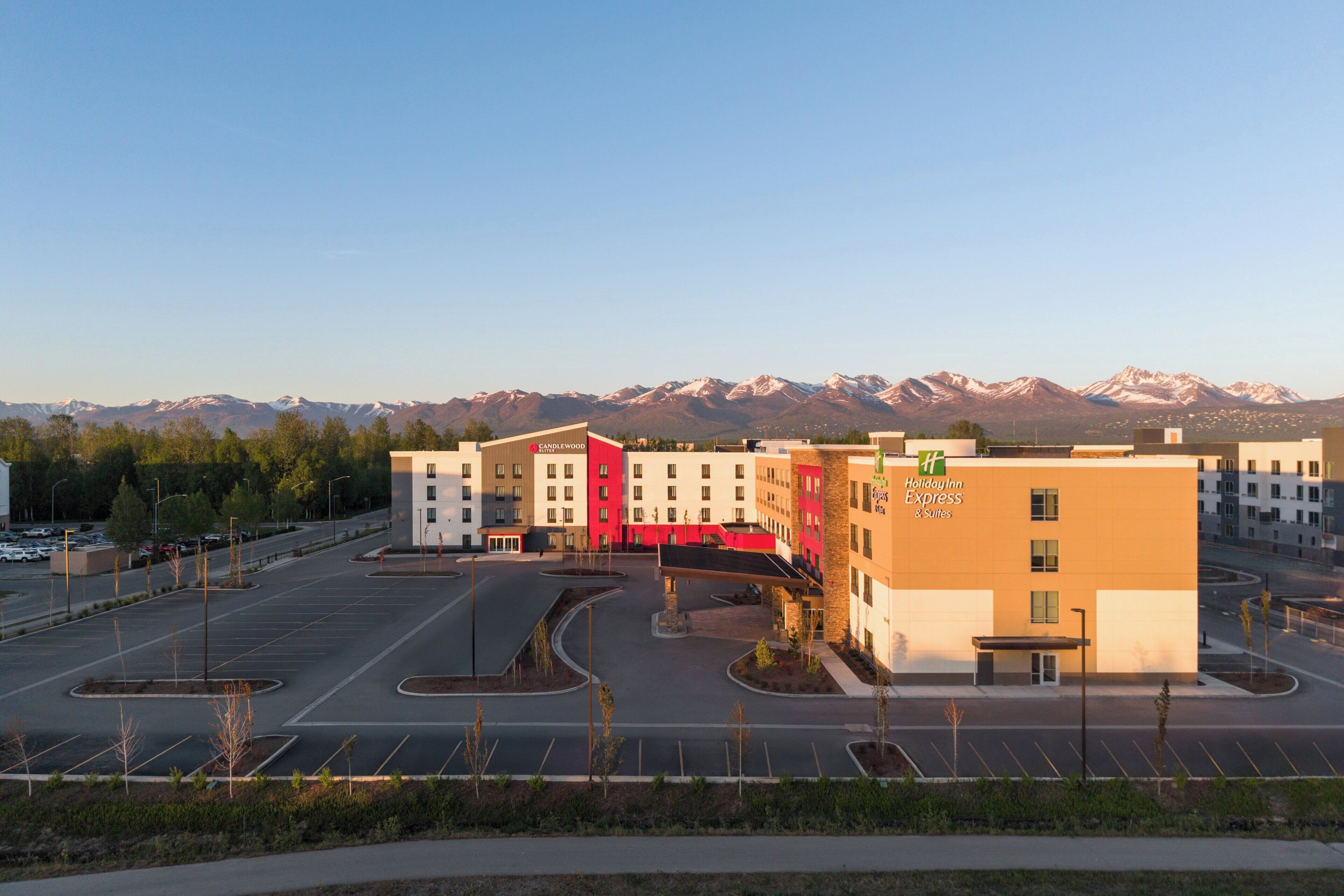 A Holiday Inn Express hotel with a parking lot and a mountain backdrop.
