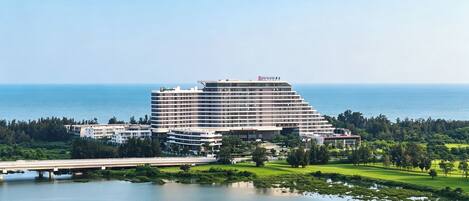 Un hotel grande con varios pisos y vista al mar.