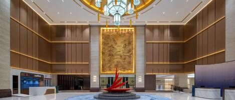 A spacious lobby with a central fountain, a reception desk, and a coffee shop.
