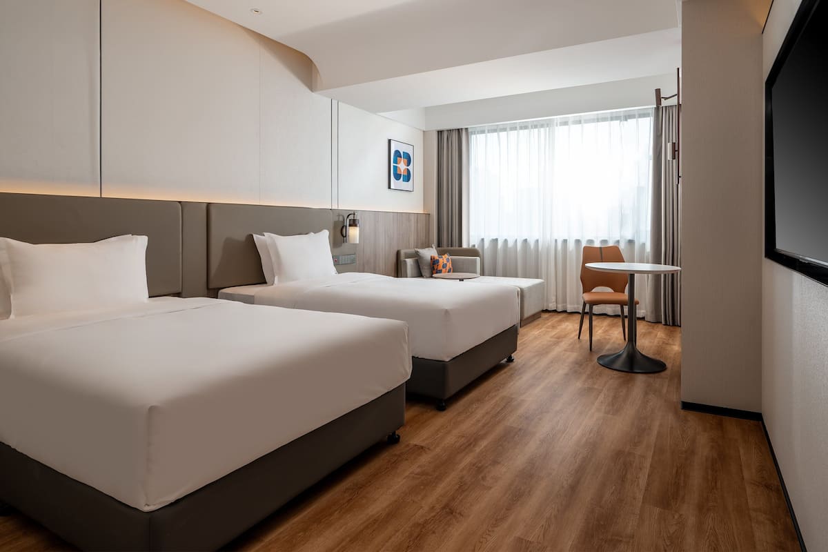 Cubrecamas, escritorio y espacio para trabajar con laptop