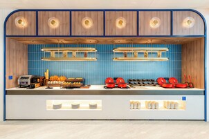 Una cocina moderna con azulejos azules, armarios de madera y una estación de café.