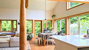 A spacious room with large windows, a dining area, and a cozy seating area.