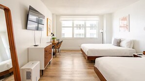 A modern bedroom with a bed, a desk, and a TV. - Beach Oasis w/ Balcony, Pool, Gym - Elevator to Beach (Miami Beach)