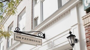 En bygning med et skilt, der siger "CH PÄTISSERIE", og et amerikansk flag.