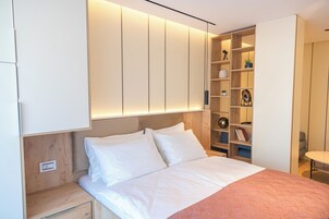 Un dormitorio con cama, armario empotrado y mesitas de noche.