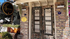 Ein Gebäude mit einer Stein-Fassade, einem Metallgitter und einem Schild, das 'MORISI Pansiyon & Kahvaltı' anzeigt.