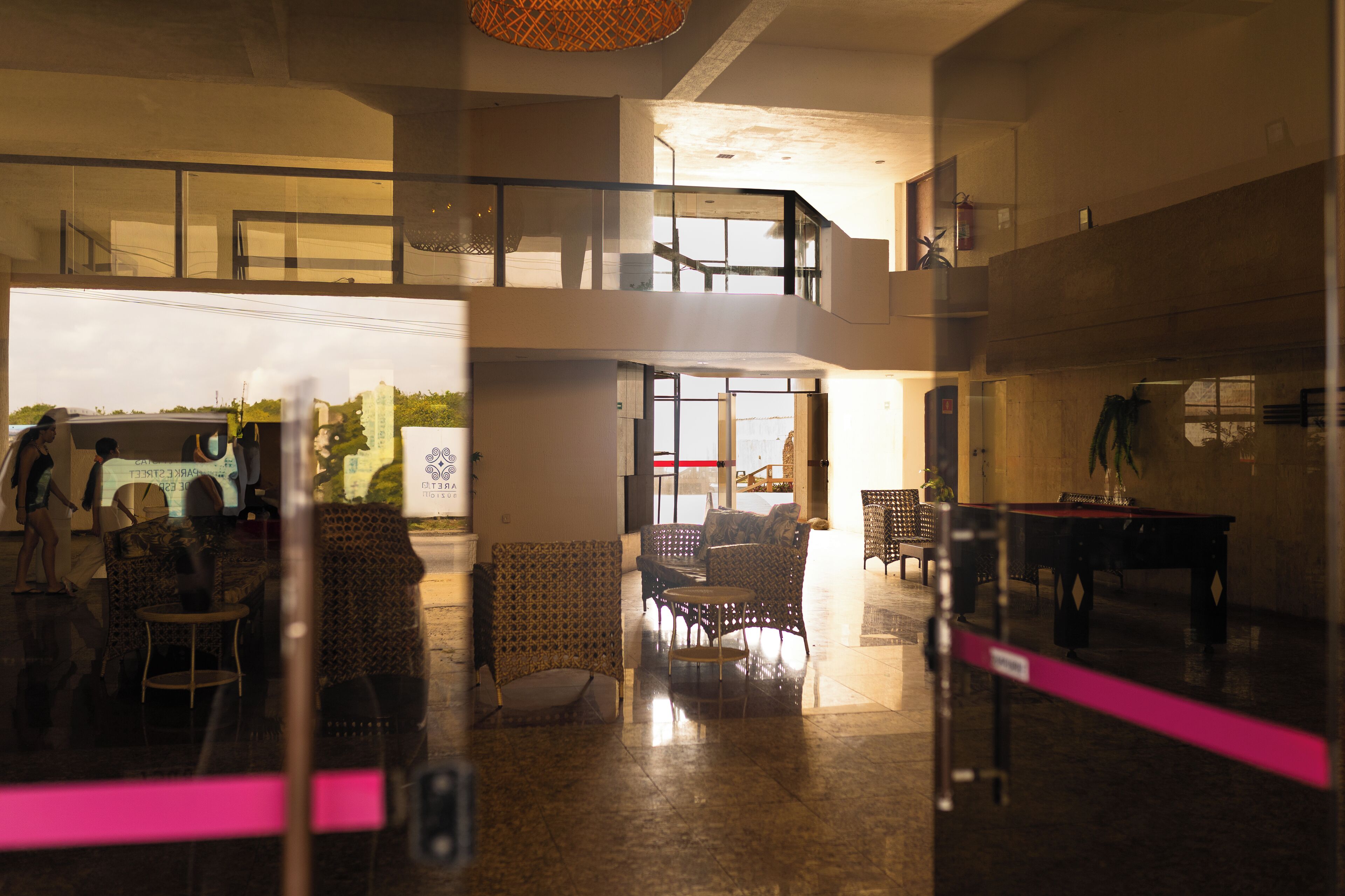 A spacious lobby with high ceilings, a billiards table, and a seating area with patterned chairs.