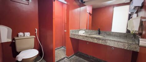Ein kleines Badezimmer mit Toilette, Waschbecken und Spiegel.