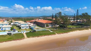 Un complejo turístico costero con varias villas, una piscina y una playa.